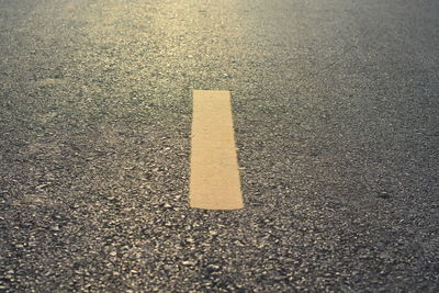 Close-up of yellow arrow symbol on road