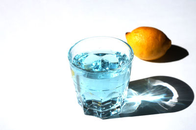 Close-up of drink against glass over white background