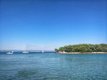 Scenic view of bay against clear blue sky