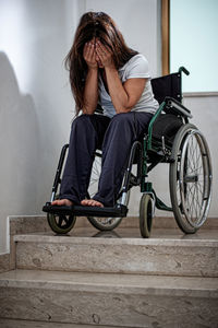 Desperate woman in a wheelchair can't go down the stairs to her apartment. difficult to access