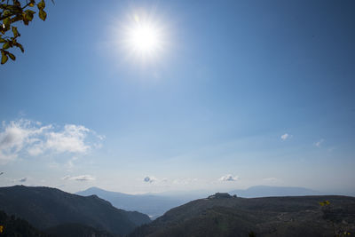 Low angle view of mountains against blue sky on sunny day