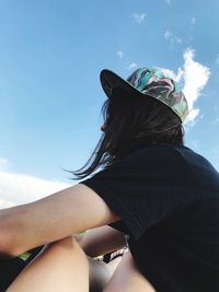 Rear view of women sitting against sky