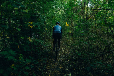 Rear view of woman cycling in forest