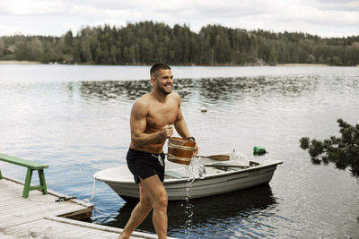 Man carrying bucket at lake