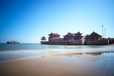 View of beach against clear blue sky