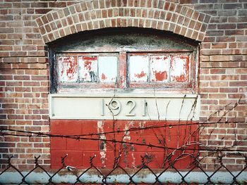 Close-up of metal structure against brick wall