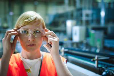 Portrait of woman in protective eyewear at factory
