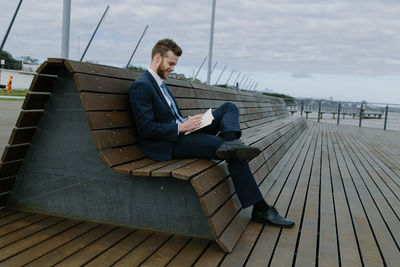 Side view of young man sitting on seat