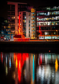 Reflection of illuminated building in river at night