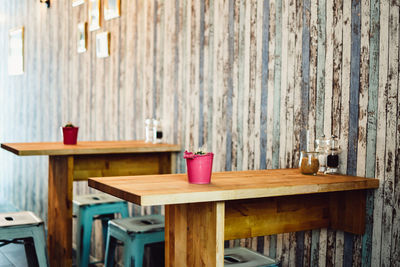 Table and chairs against wall in cafe