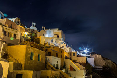 Low angle view of illuminated buildings against sky at night