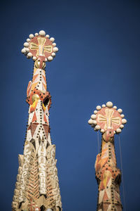 Low angle view of statue against temple against clear blue sky