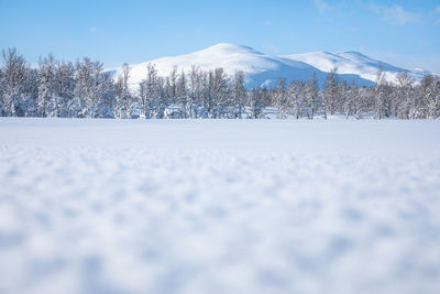 Snow covered land against sky