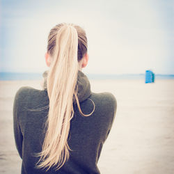 Woman with long blond hair standing on beach