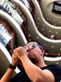 Low angle view of man igniting cigarette