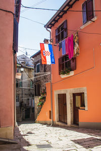 Clothes drying on alley amidst buildings in city