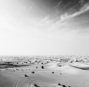 Scenic view of arid landscape against sky on sunny day