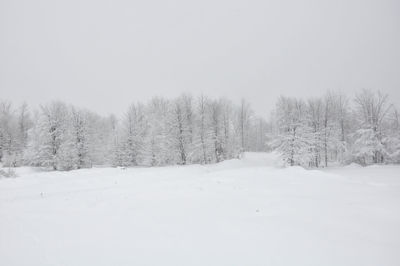 Snow covered landscape against clear sky