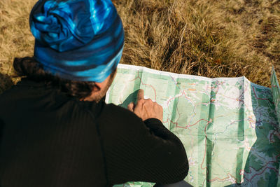 Man checking his way on route with map on a grass.