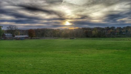 Scenic view of field against cloudy sky