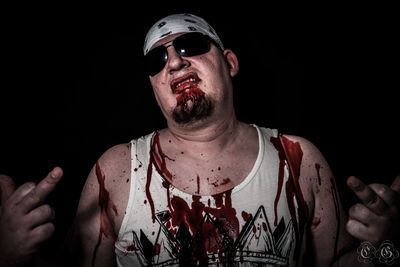 Portrait of young man against black background