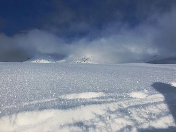 Snow covered landscape against sky