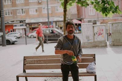 Full length of smiling man standing in city