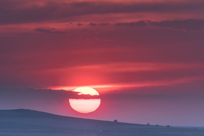 Scenic view of sea against dramatic sky during sunset