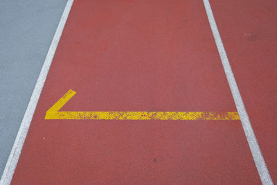 High angle view of yellow arrow sign on the ground