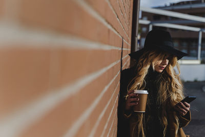 Full length of young woman using mobile phone