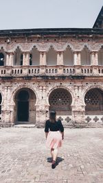 Rear view of woman walking at historical building