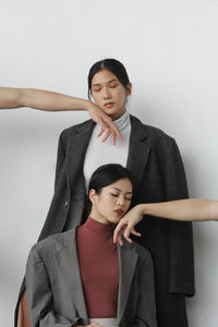 Young couple sitting against white background