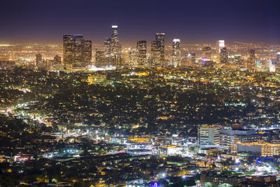 Illuminated cityscape against sky at night