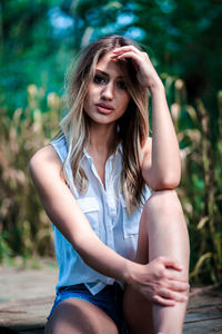 Portrait of a beautiful young woman sitting outdoors