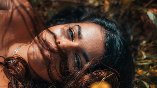 High angle portrait of young woman lying on field