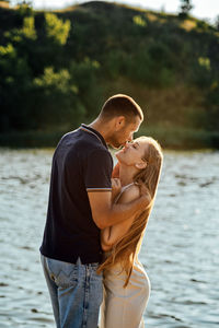 Declarations of love, candid couple in love holding hands on nature background.