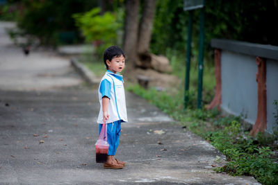 Side view of cute boy standing outdoors