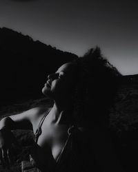 Sensuous young woman with eyes closed against sky