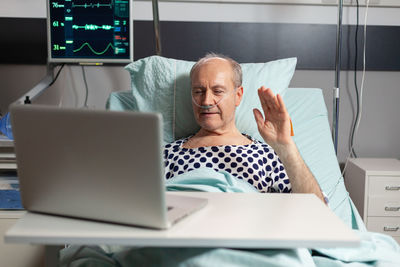 Midsection of man using mobile phone while sitting on table