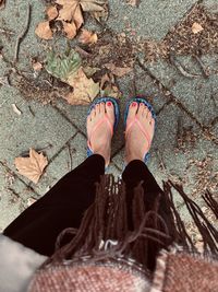 Low section of woman standing on leaves