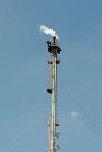 Low angle view of crane against sky