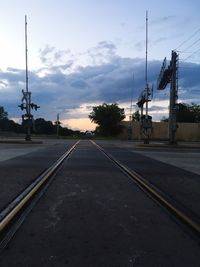 Railroad tracks by road against sky