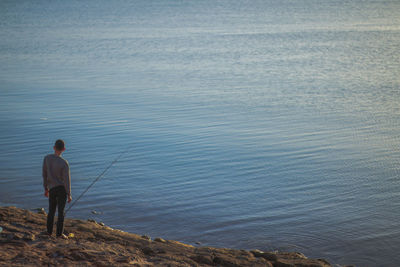 Rear view of man fishing in sea