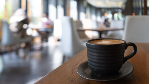 Coffee cup on table with blur background cafe