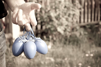 Close-up of hand holding decoration hanging outdoors