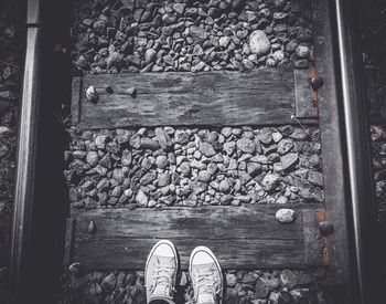 Low section of person standing on railroad track