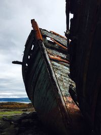 Low angle view of damaged boat against sky