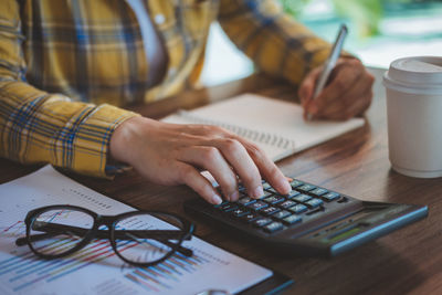 Midsection of man using laptop on table