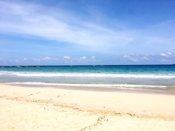 Scenic view of beach against blue sky