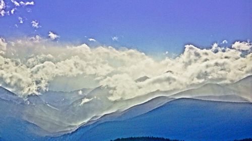 Scenic view of mountains against blue sky